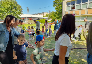 Dzieci i rodzice poruszają się w rytm piosenki "Karuzela".