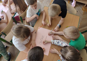 Dzieci rysują owoce przy stoliku.