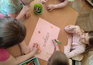 Kamil z dziewczykami rysują warzywa na kartce.