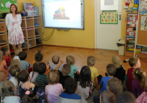 Pani Ilona przedstawia na tablicy prezentację o pracy bibliotekarza.