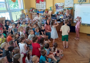 Karolina, Zuzia i Tymon z grupy Biedronek chodzą z książkami na głowach.