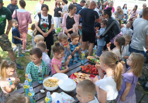 Chłopcy i dziewczynki z grupy „Słoneczek” smakują owoce i słodkości.