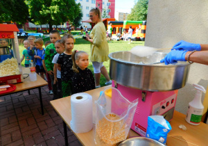 Dzieci cierpliwie oczekują w kolejce na swoją watę cukrową.