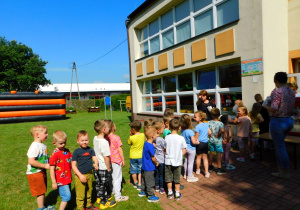 Dzieci cierpliwie czekają w kolejce do cukrowej waty i popcornu.