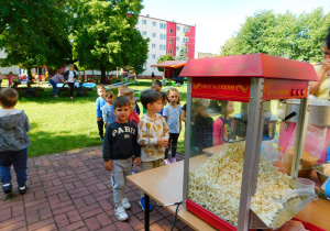 Jasiu i Mieszko stoją w kolejce po popcorn.