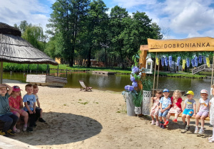 Dzieci z grupy Misiaczków pozują do zdjęcia na plaży.