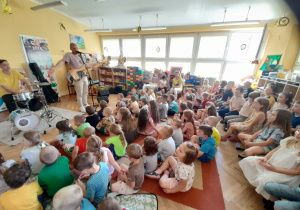 Przedszkolaki zainteresowaniem słuchają muzyki koncertu.