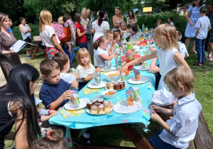 Dzieci częstują się słodkościami przygotowanymi przez rodziców.