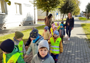 Grupa Krasnoludków, ze swoim gościem, spaceruje przy ulicy Jana Pawła II.