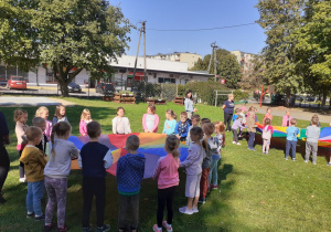 Przedszkolaki trzymają chustę animacyjną.