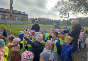 Chłopcy i dziewczynki pokazują prawą ręką kierunek jazdy auta.