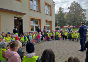 Dzieci stoją przed panem policjantem.