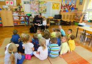 Tata Emilki z grupy Misiaczków czyta dzieciom bajkę pt. Mulan.