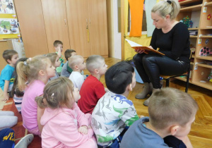 Mama Zuzi z grupy Biedronek czyta dzieciom bajkę pt. Basia i przedszkole.