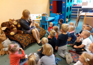 Pani Joasia czyta dzieciom bajkę o Kamyczku, który pierwszy raz odwiedził bibliotekę. 