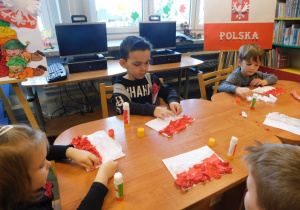 Dzieci wykonują polską flagę