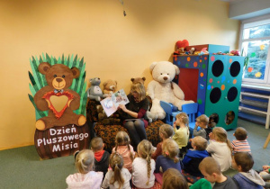 Przedszkolaki słuchają opowiadania o niedźwiedziu polarnym i jego przyjaciołach czytaną przez bibliotekarkę.