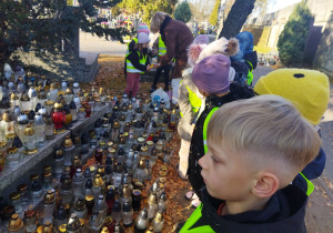 Oliwka z panią Anią zapalają znicz.