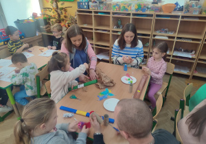 Rodzice przygotowują materiały do wykonania kukiełek.