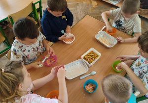 Dzieci przeliczają i segregują produkty sypki.