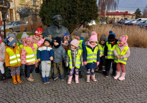 Dzieci stoją przy pomniku Jana Łaskiego.