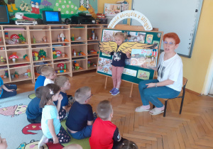 Podczas zajęć przyrodniczych Pani Agnieszka pokazuje Krasnoludkom ilustracje w książce „Co się kryje pod ziemią”.