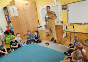 Przedszkolaki oglądają czujnik dymu.