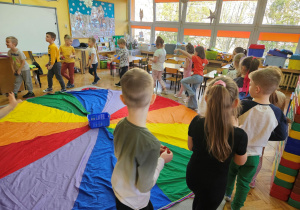 Dzieci z grupy "Biedronek" tańczą wokół chusty animacyjnej podczas zabawy "Kolorowe śnieżynki".