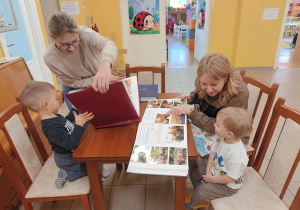 Szymon i Nikoś z mamami oglądają kroniki przedszkola.