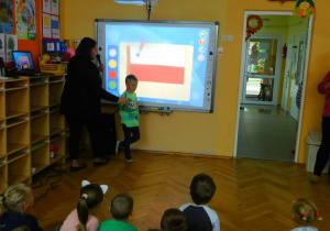Natan z grupy Biedronek koloruje flagę Polski.