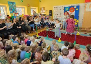 Dwie Oliwie prezentują długie suknie na wybiegu.