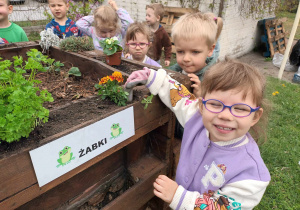 Zuzia uśmiecha się, widząc posadzone kwiaty.