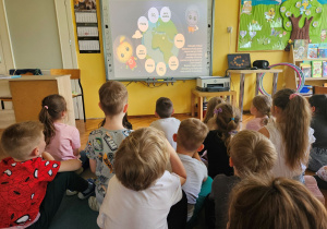 Dzieci z grupy "Biedronek" oglądają film edukacyjny co wpływa na jakość naszego środowiska
