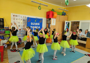 Dziewczynki z koła tanecznego prezentują figurę w tańcu