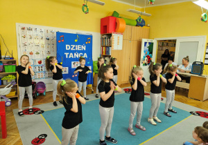 Dziewczynki z koła tanecznego prezentują figurę w tańcu