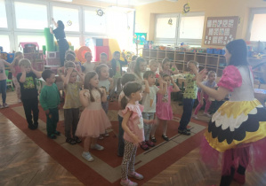 Dzieci wykonują określone ruchy do muzyki.