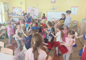 Wspólna zabawa dzieci z pomponami.