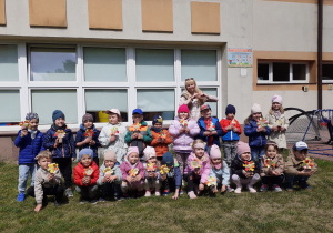 Grupa Krasnoludków pozuje z prowadzącą do pamiątkowego zdjęcia.