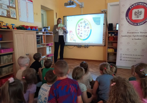 Pani Patrycja za pomocą talerzyka z przegródkami pokazuje w jakich proporcjach dzieci powinny zjadać poszczególne produkty.