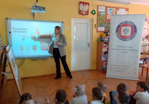Prowadząca pokazuje na ekranie produkty zbożowe.
