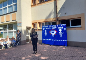 Pani Dyrektor stoi z mikrofonem i wita wszystkich uczestników uroczystości.
