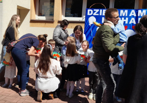 Rodzice odbierają laurki i tulą swoje dzieci.