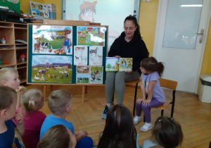 Pani Martyna pokazuje dzieciom ilustracje w książce.