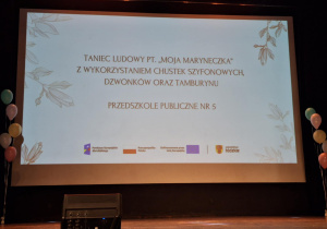 Prezentacja na tablicy z nazwą przedszkola i tańcem