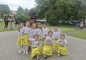 Dziewczynki wraz panią Kamilką pozują na placu przed Łaskim Domem Kultury