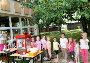 Dziewczynki z „ Krasnoludków”stoją w kolejce po watę cukrową .