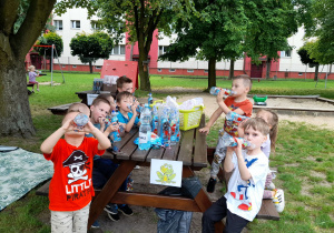 Grupa ,,Żabek " pije wodę z butelek.