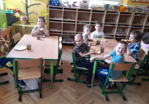 Zadowolone dzieci jedzą pizzę.