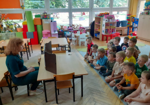 Pani Ilona zza teatrzyku czyta dzieciom opowieść.