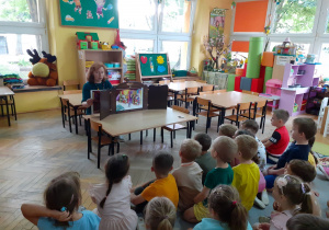 Grupa słuch bajki i obserwuje jak Pani Ilona zmienia ilustracje.